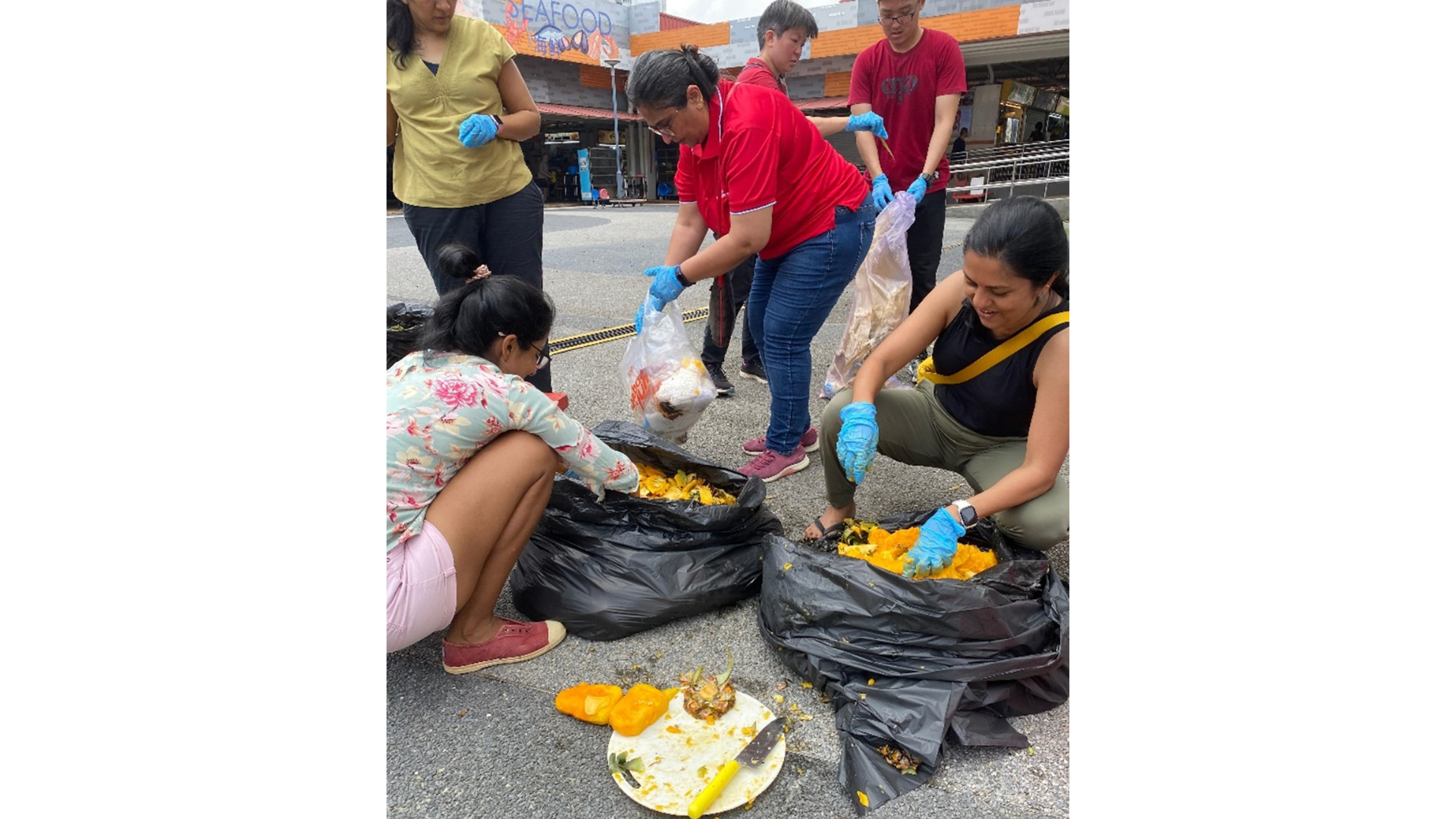 Volunteers separating food waste from inorganic waste in trash bags